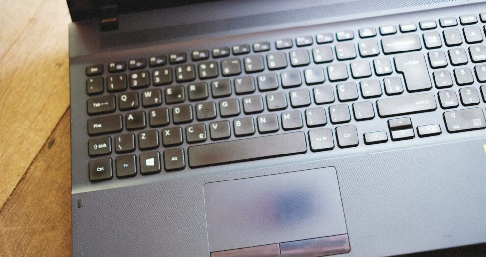 a laptop computer sitting on top of a wooden table