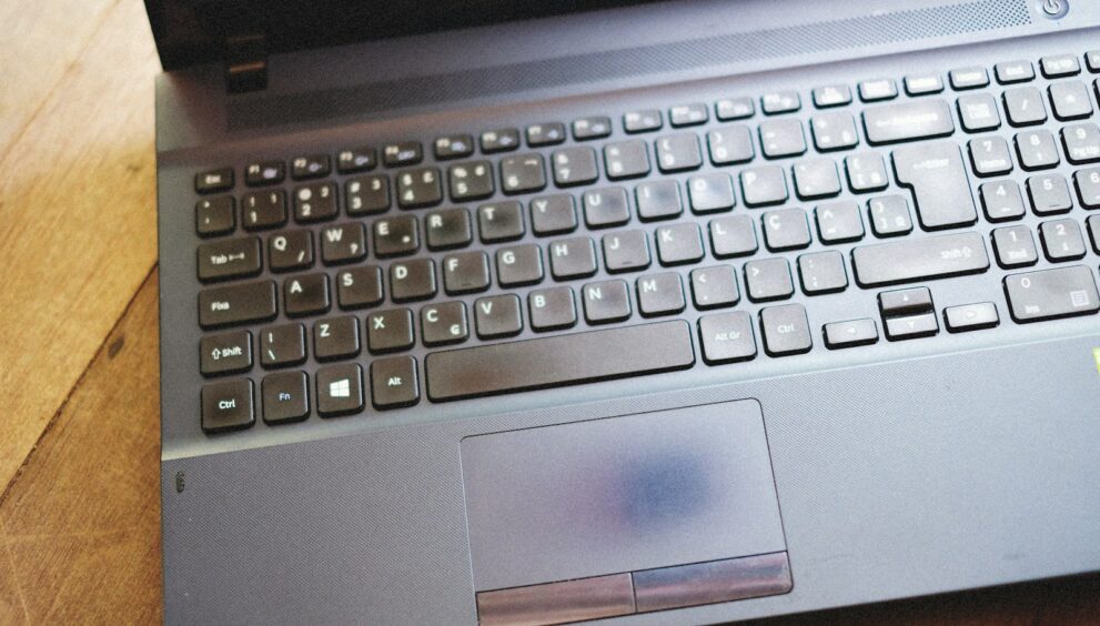 a laptop computer sitting on top of a wooden table