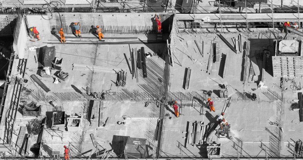 selective color photo of man on top of gray building